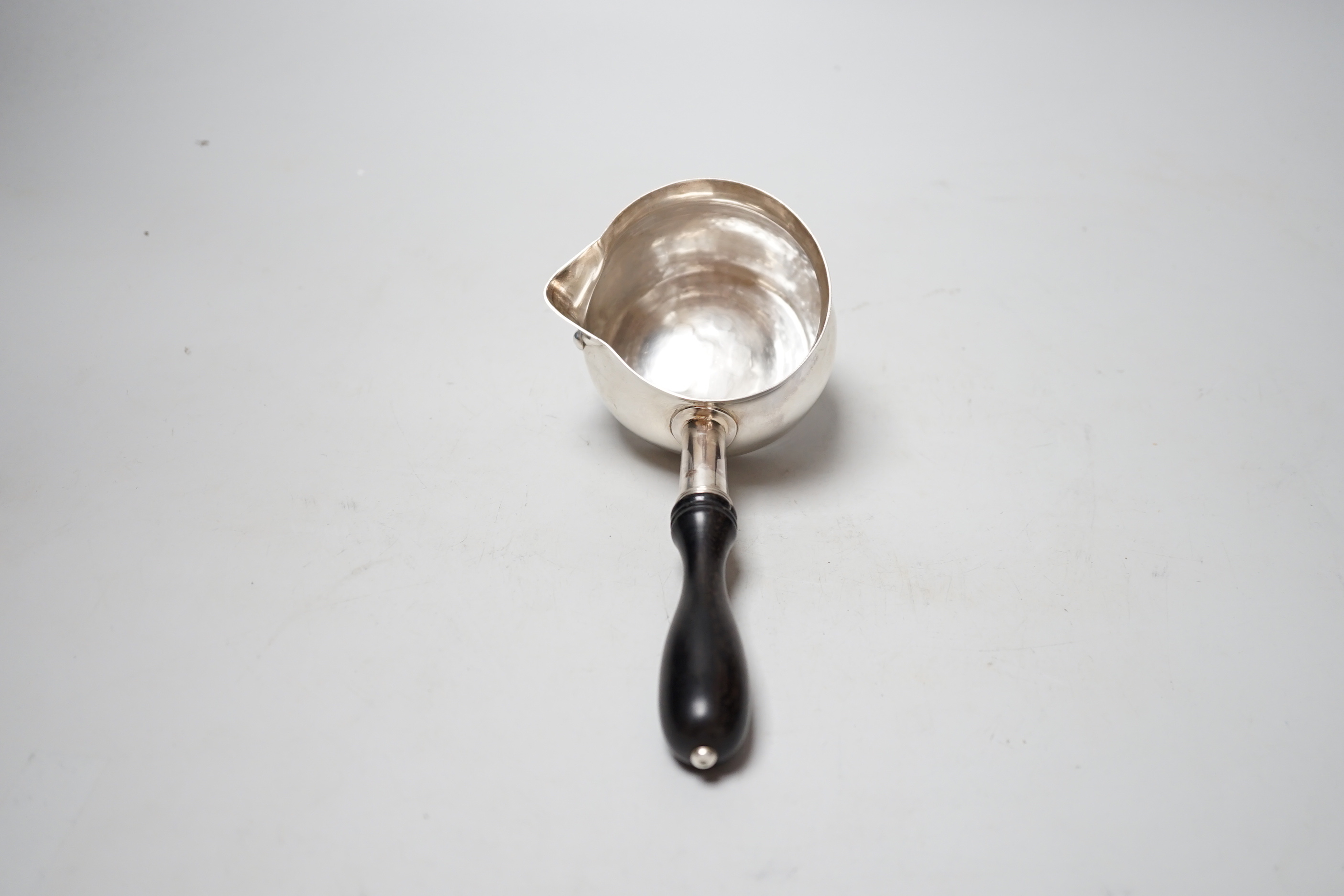 A modern silver brandy pan, with turned ebonised handle, maker, I*R, London 2002, length approx. 19.6cm, gross weight 4.9oz.